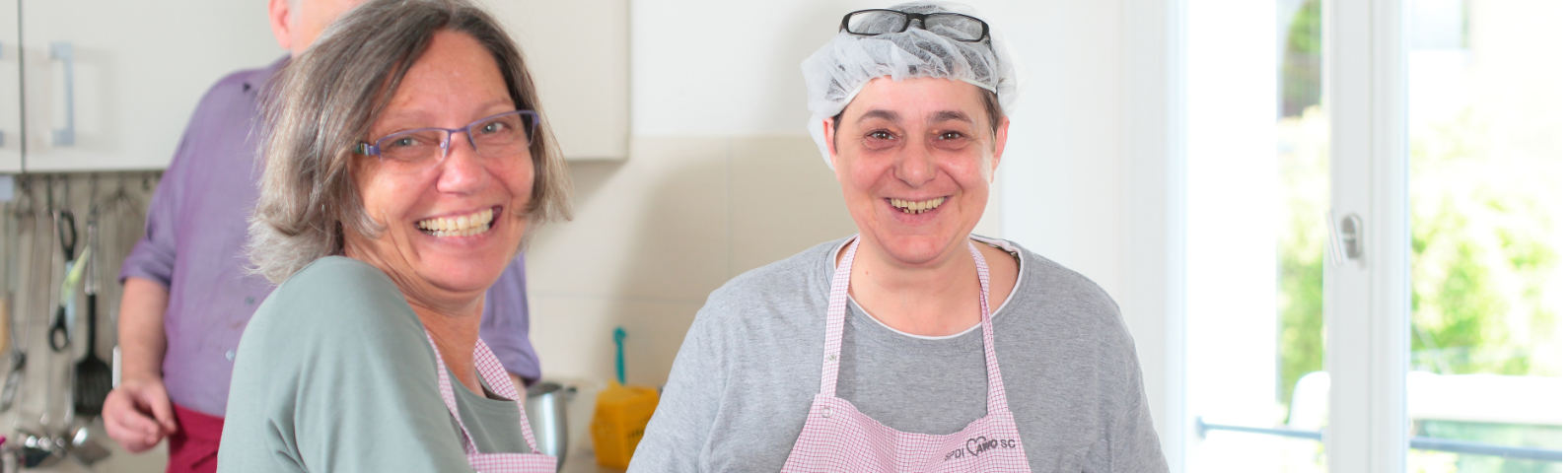 Zwei schürzentragende Frauen beim Kochen