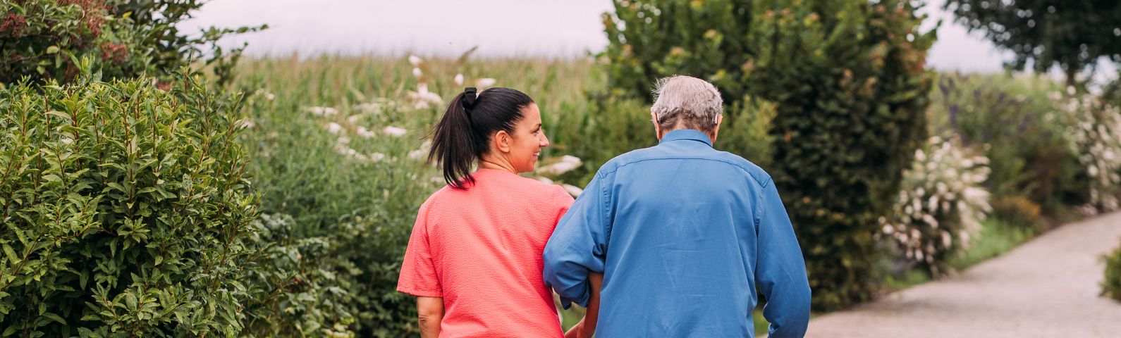 Pflegerin und führt Mann durch den Garten