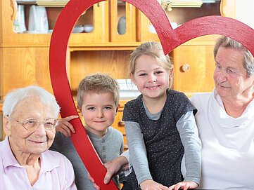 ältere Damen mit Kindern und Herz-Bogen