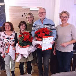 Gruppenfoto mit vier Frauen und einem Mann. Drei Personen haben Urkunden und Blumensträuße in den Händen.
