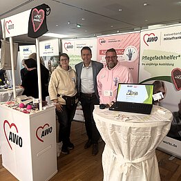 Zwei Personen mit AWO-Hoodie zusammen mit Ben Schwarz am AWO-Messestand.