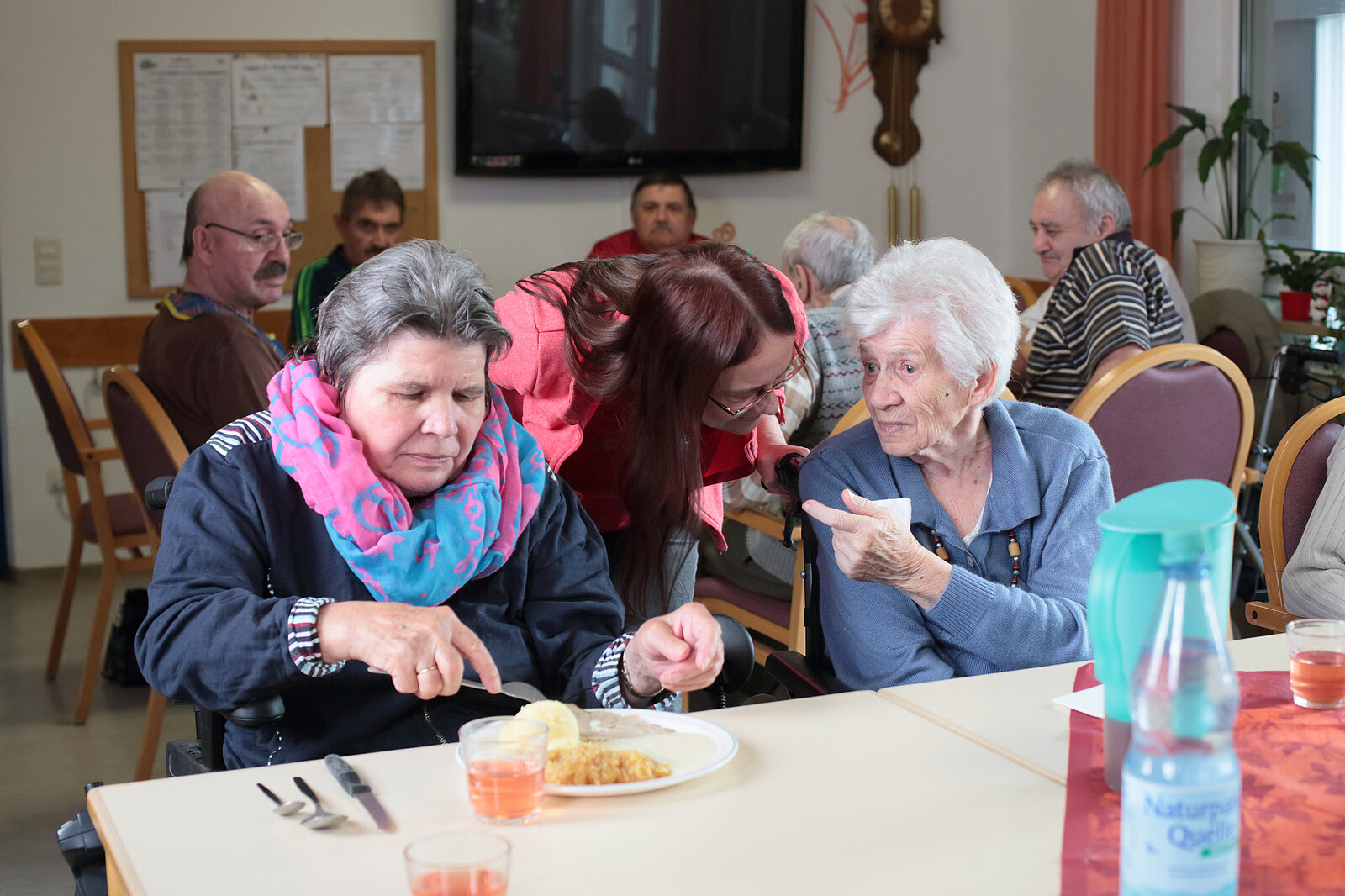2 Seniorinnen beim Essen mit Betreuerin