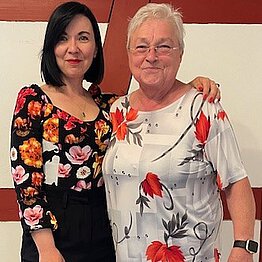 Junge Frau mit schwarzen Haaren und ältere Frau mit weißen Haaren.
